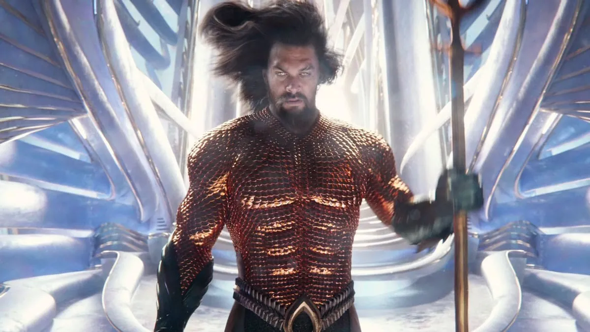 Aquaman, cheveux au vent et trident à la main, s’avance dans un palais d’Atlantis