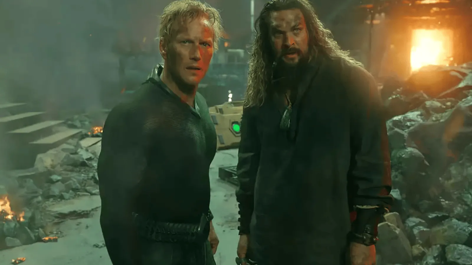 Patrick Wilson (Orm) et Jason Momoa (Arthur) côte à côte au milieu de décombres en feu