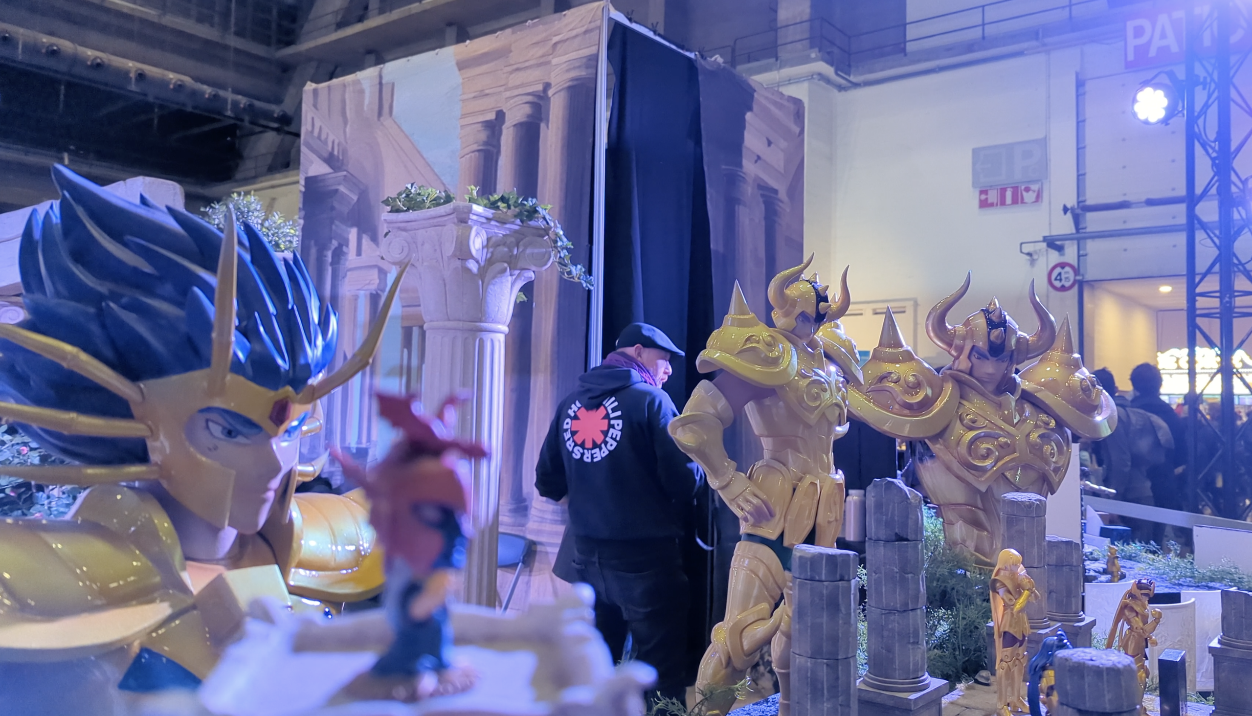 Grandes statues de chevaliers d’or et visiteurs du salon derrière le décor de colonnes