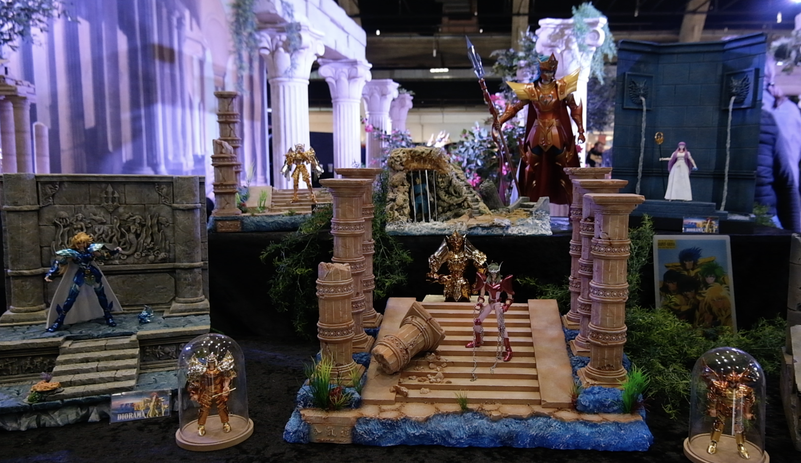 Diorama de chevaliers d’or et de Seiya sur un escalier en ruine, entre colonnes et cloches de verre