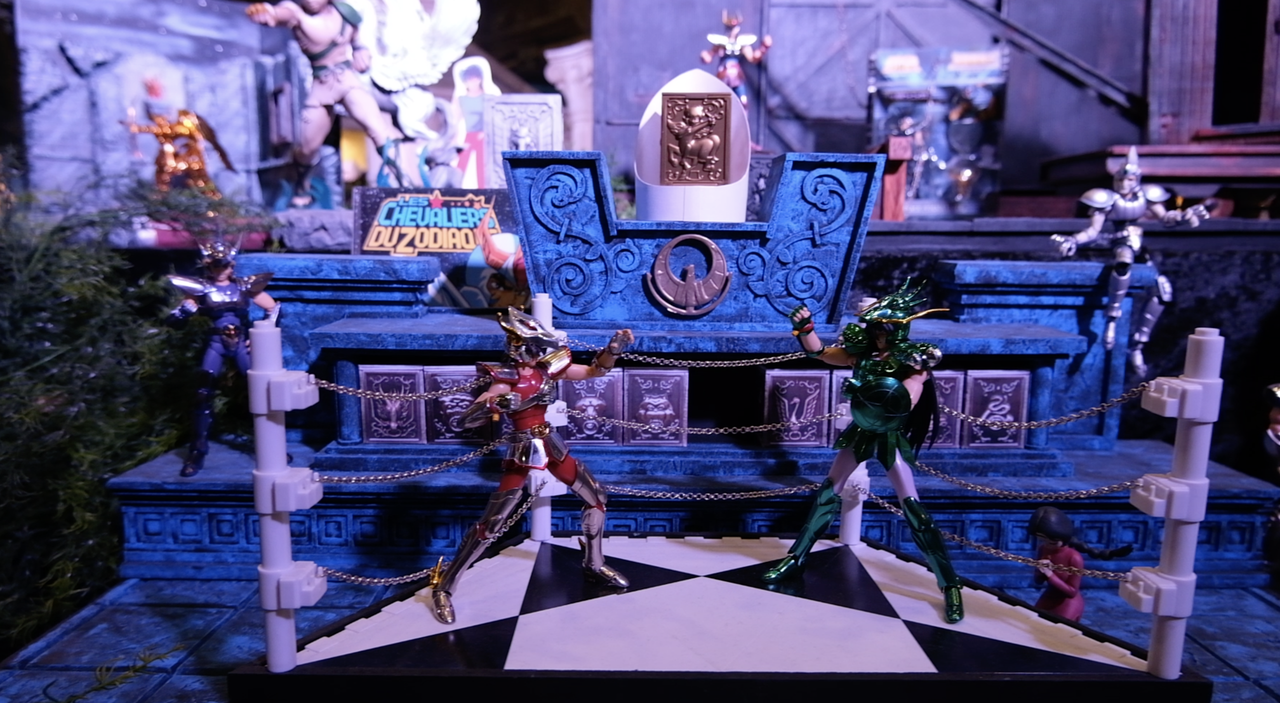 Figurines de chevaliers autour du ring miniature, à côté d’un décor de glace