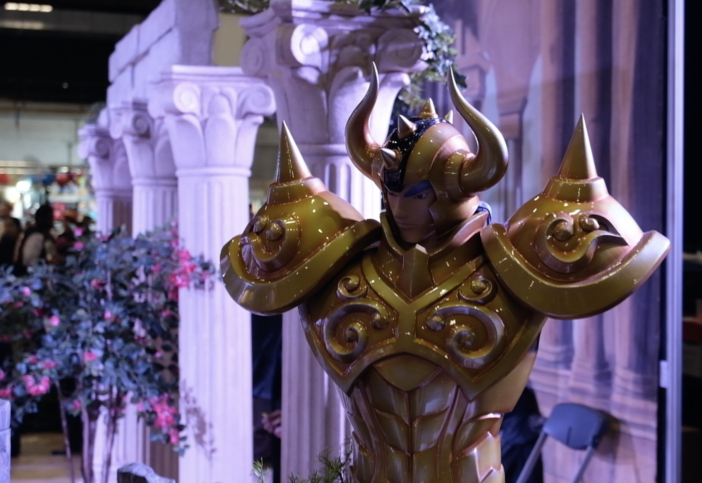 Grand buste d’un chevalier d’or au casque à cornes devant des colonnes fleuries