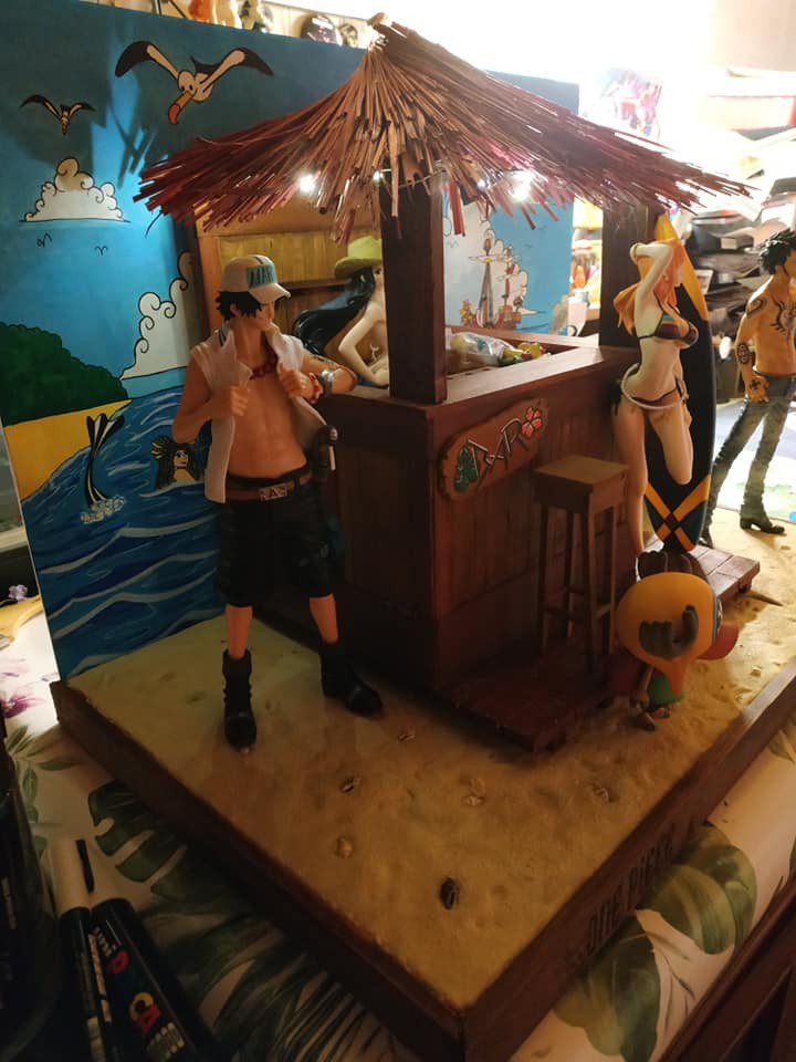Bar de plage One Piece en cours de montage, entouré de plusieurs figurines