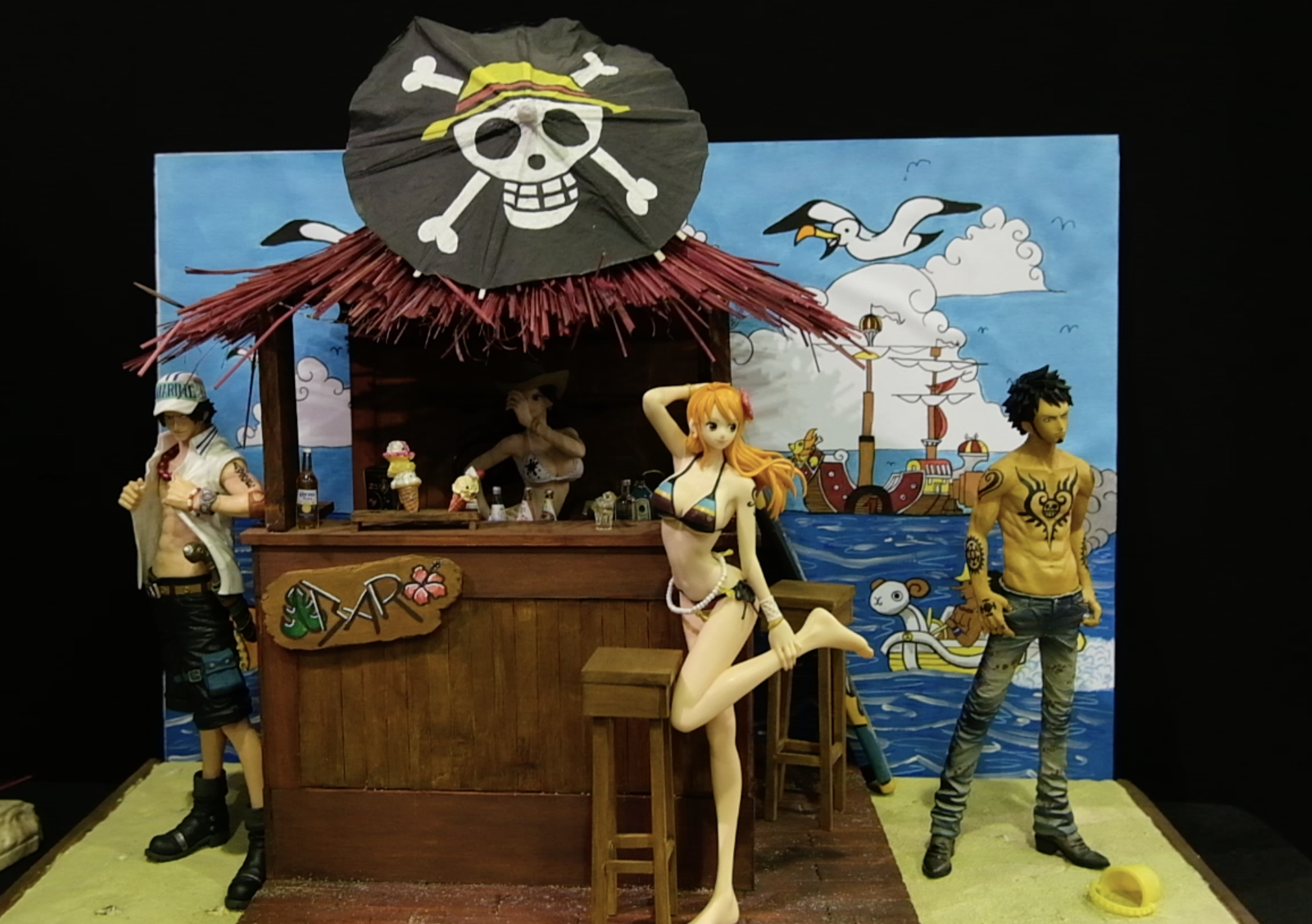 Autre vue du diorama One Piece&nbsp;: le bar de plage avec Nami, Trafalgar Law et d’autres figurines