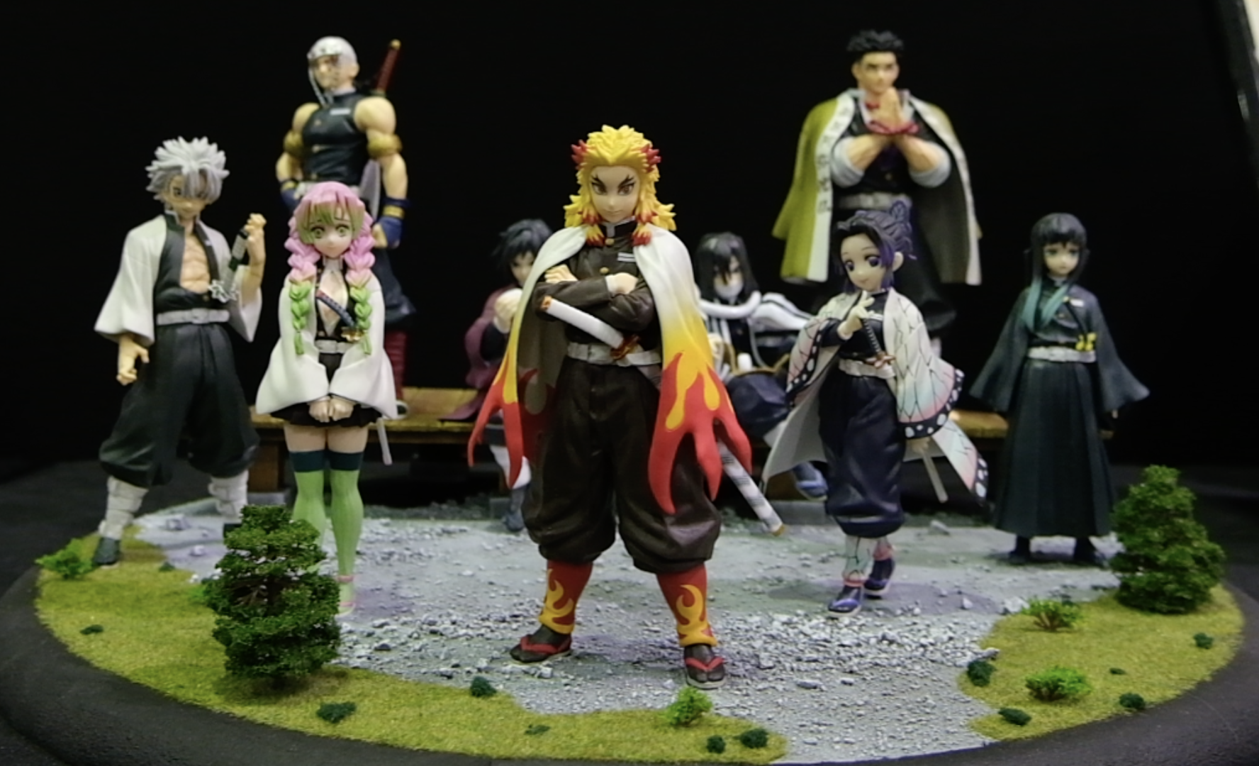 Diorama Demon Slayer&nbsp;: Rengoku entouré des autres Piliers sur un terrain de gravier