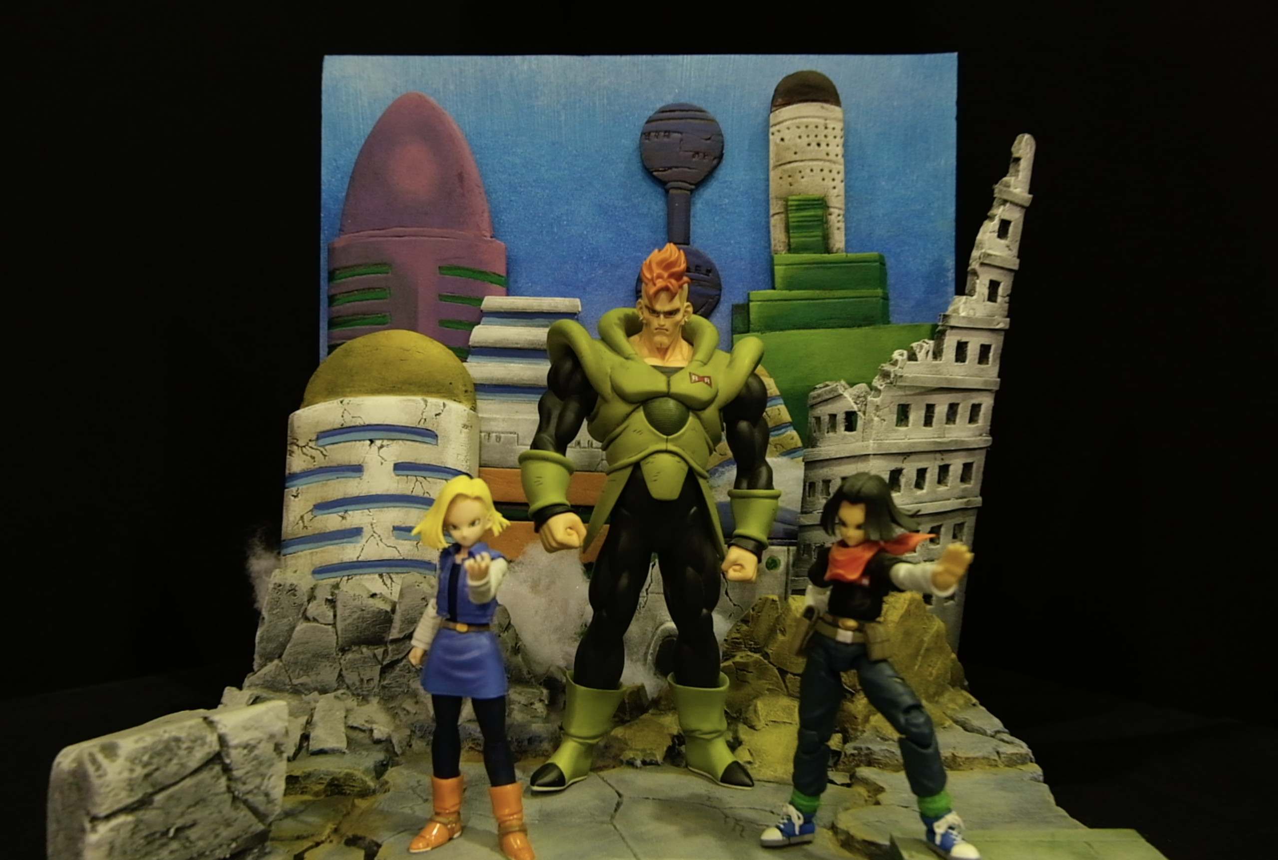 Diorama Dragon Ball Z avec C-16, C-17 et C-18 sur un sol de rochers brisés