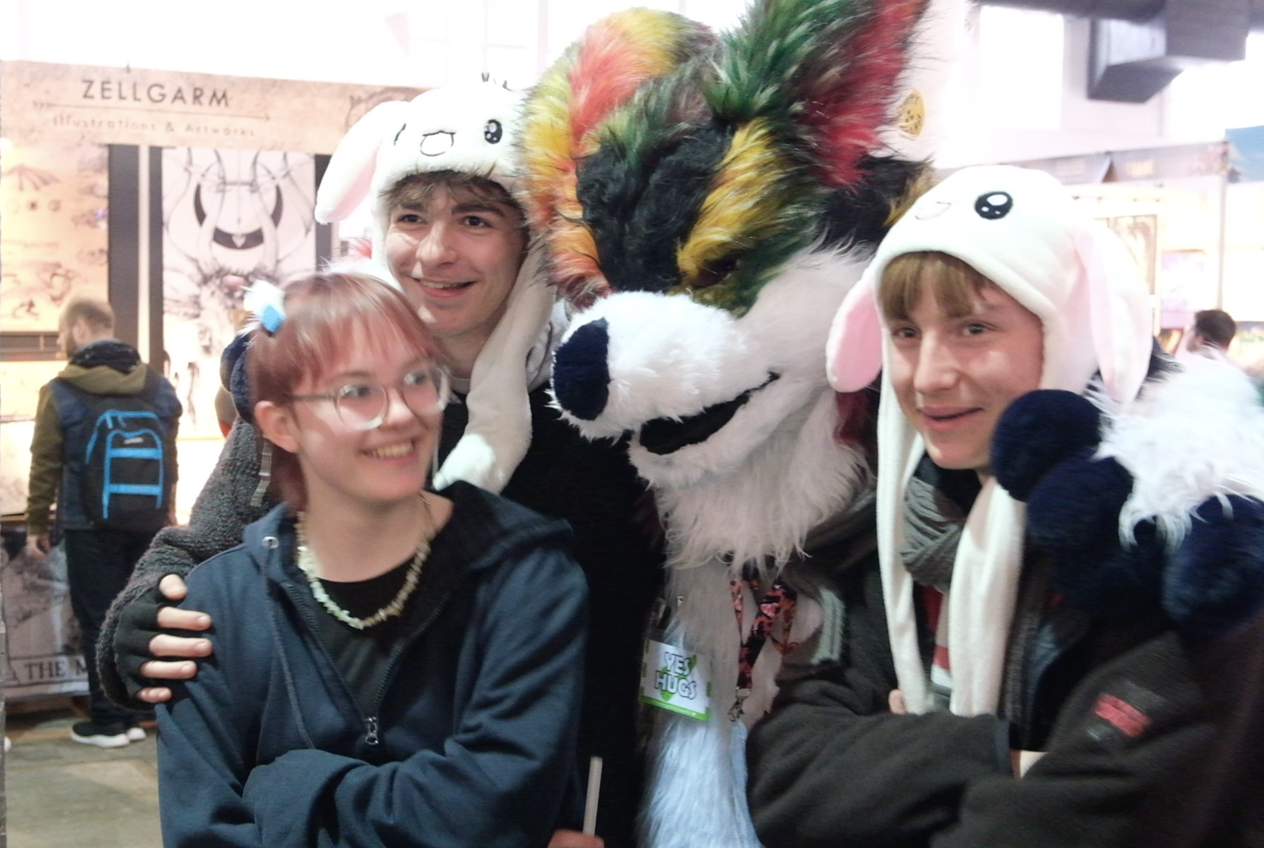 Visiteurs de la Made In Asia posant avec une mascotte en costume de fourrure multicolore