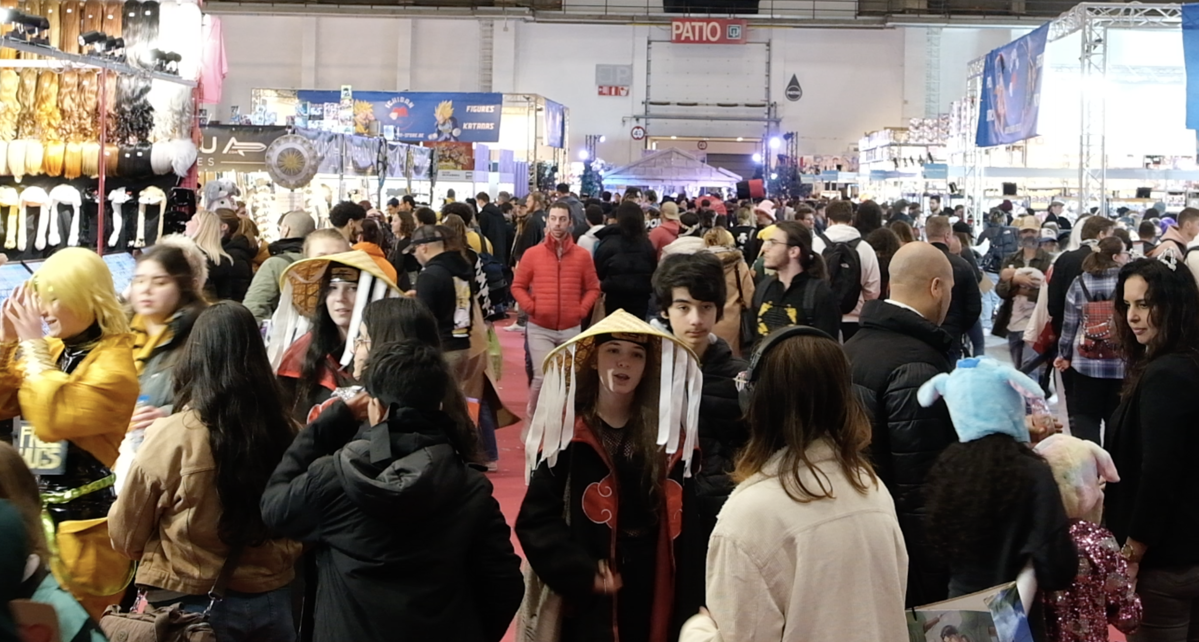 Foule et cosplayeurs en manteau de l’Akatsuki dans les allées d’un salon