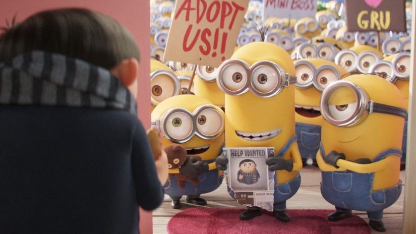 Le jeune Gru de dos face à une foule de Minions brandissant des pancartes