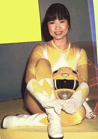 Thuy Trang en costume de ranger jaune, assise, son casque sur les genoux