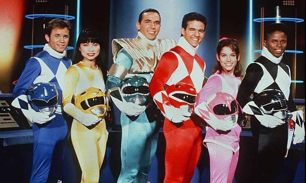 Les six Power Rangers de la série originale en costume, casque à la main