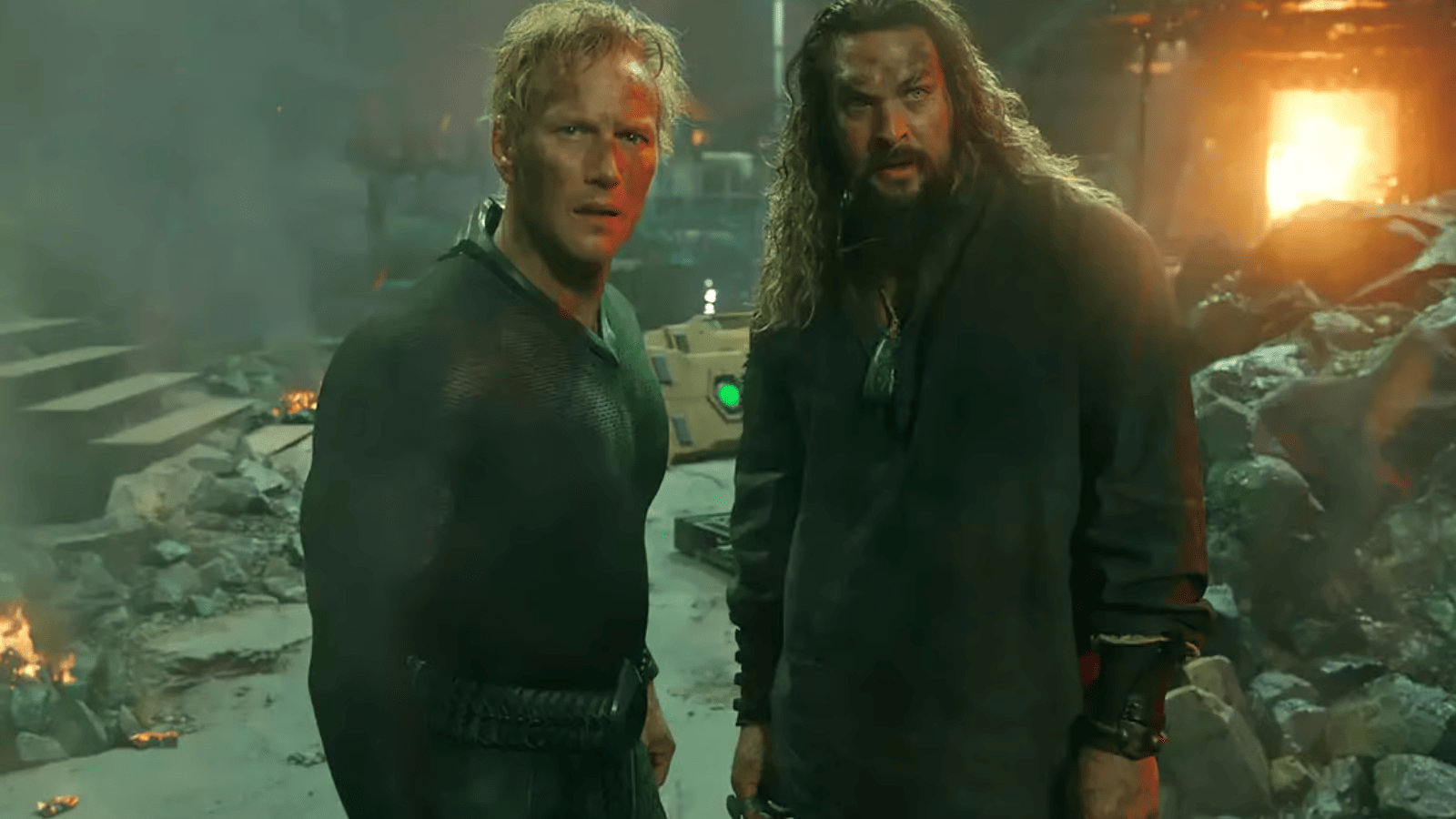Patrick Wilson (Orm) et Jason Momoa (Arthur) côte à côte au milieu de décombres en feu