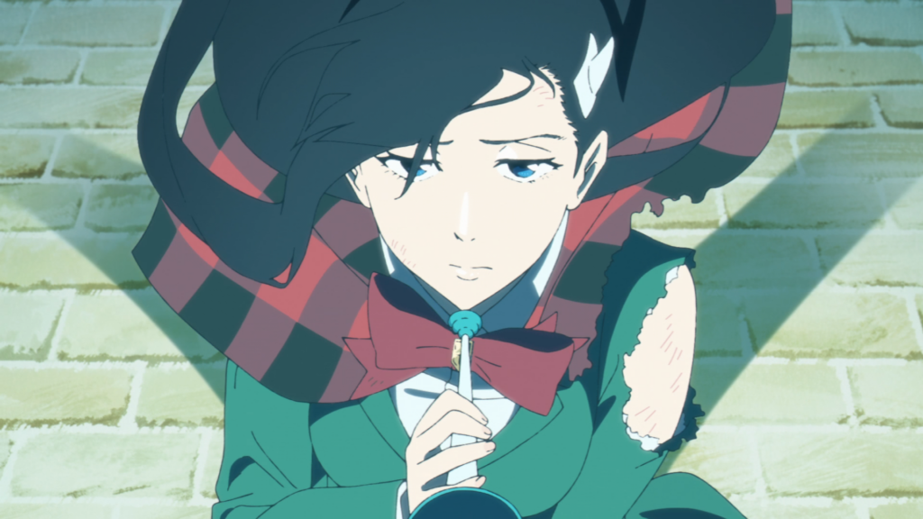Noel Niihashi, écharpe à carreaux et nœud rouge, devant un mur de briques dans l’anime BURN THE WITCH