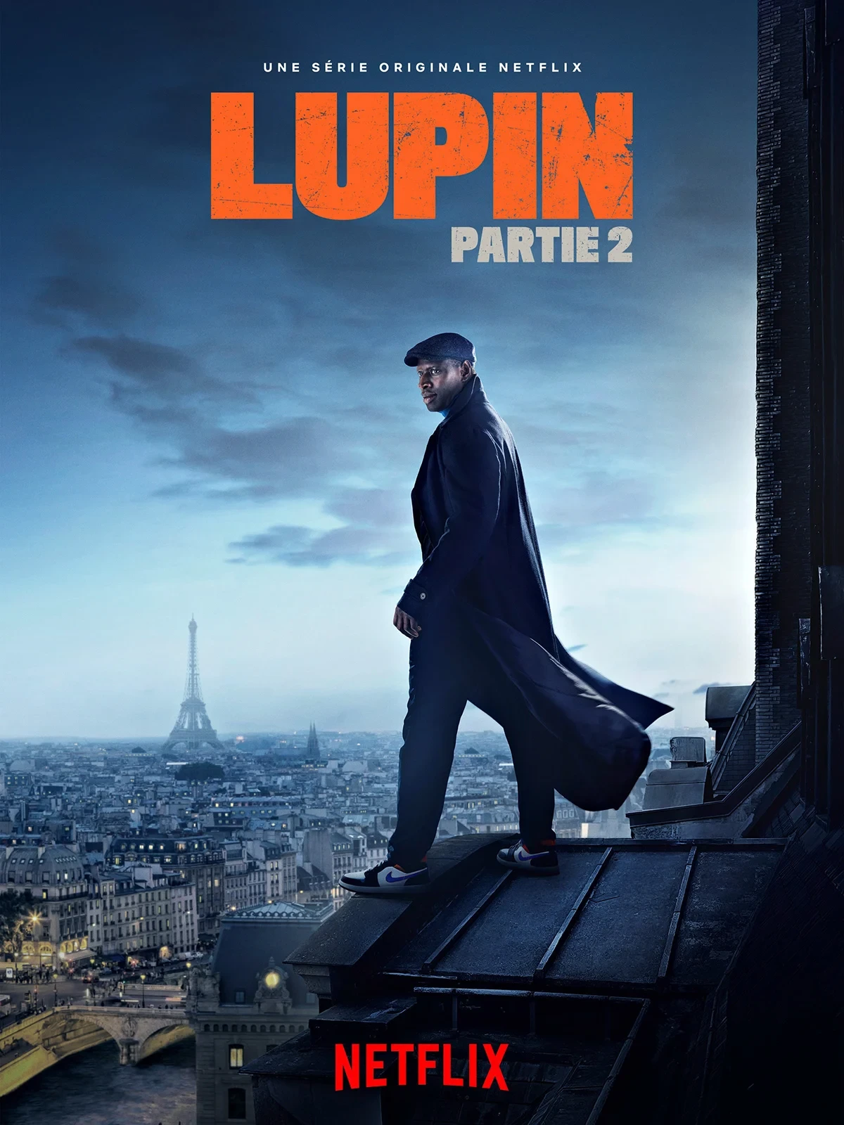 Affiche de Lupin partie 2&nbsp;: Omar Sy sur un toit de Paris, la tour Eiffel au loin