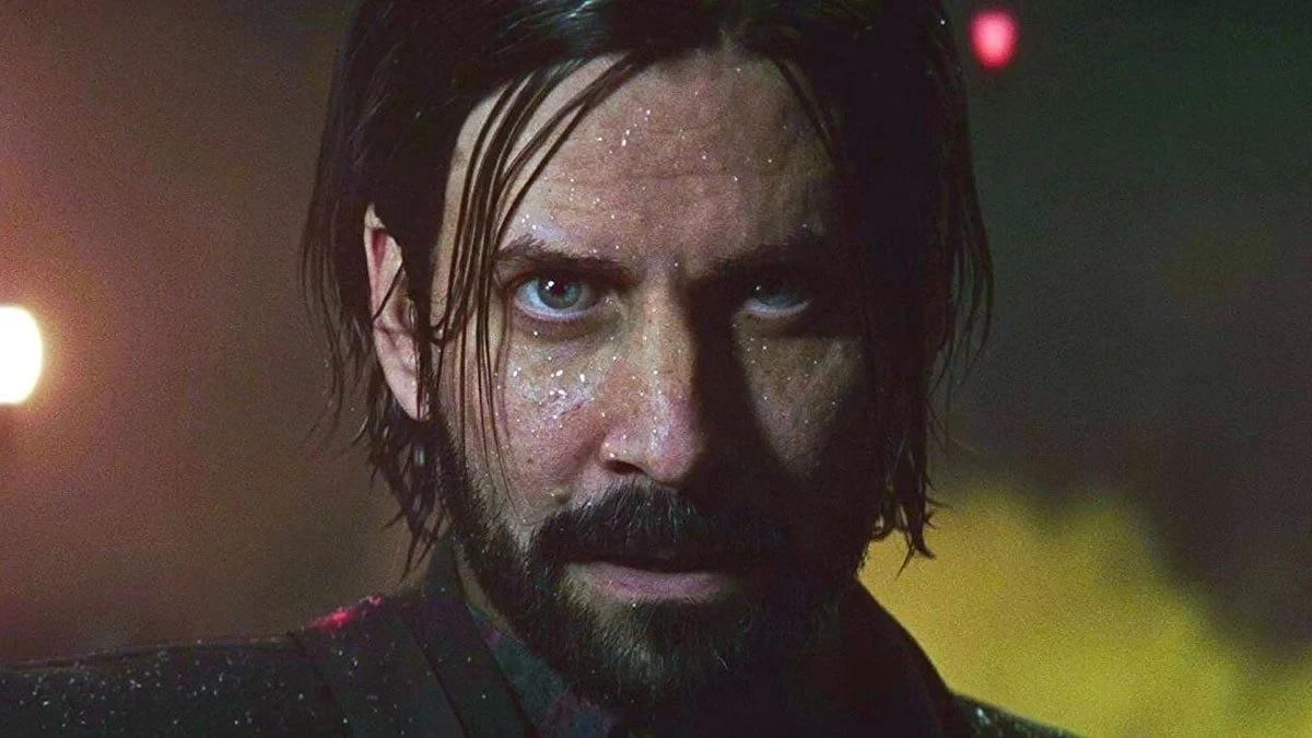 Gros plan sur le visage barbu et trempé d’Alan Wake, cheveux longs plaqués, regard fixe