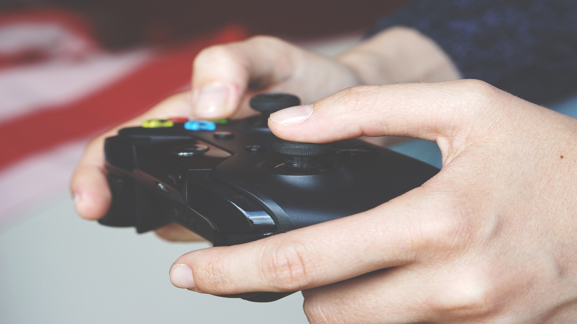Gros plan sur deux mains tenant une manette de console noire