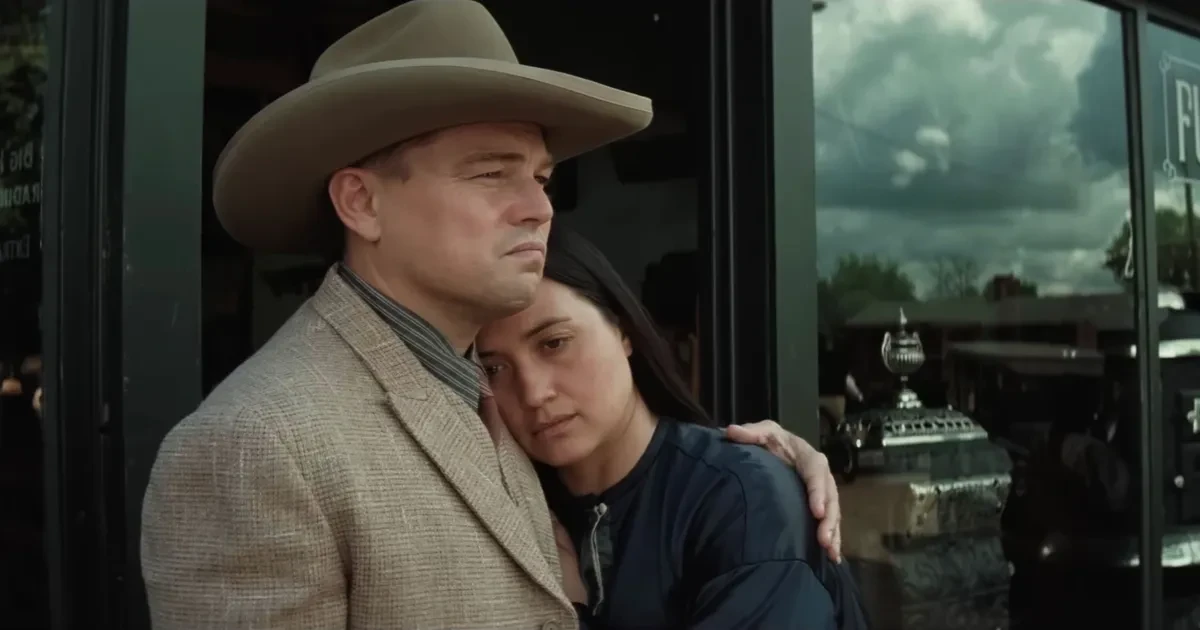 Leonardo DiCaprio et Lily Gladstone enlacés devant une vitrine dans Killers of the Flower Moon