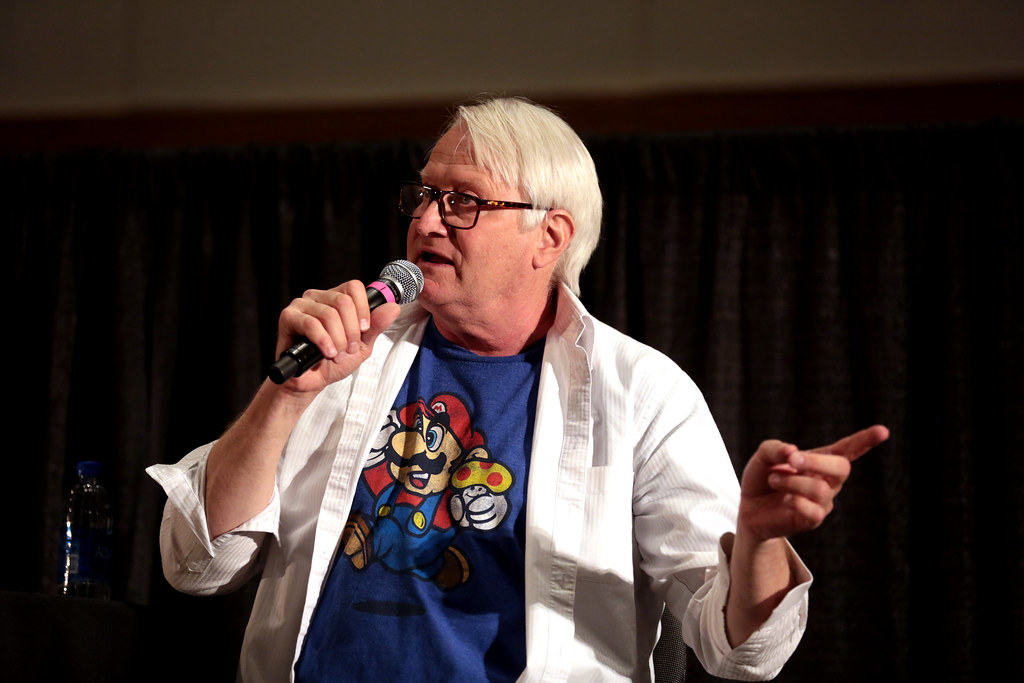 Charles Martinet, micro en main et t-shirt Mario, s’adressant au public lors d’une conférence