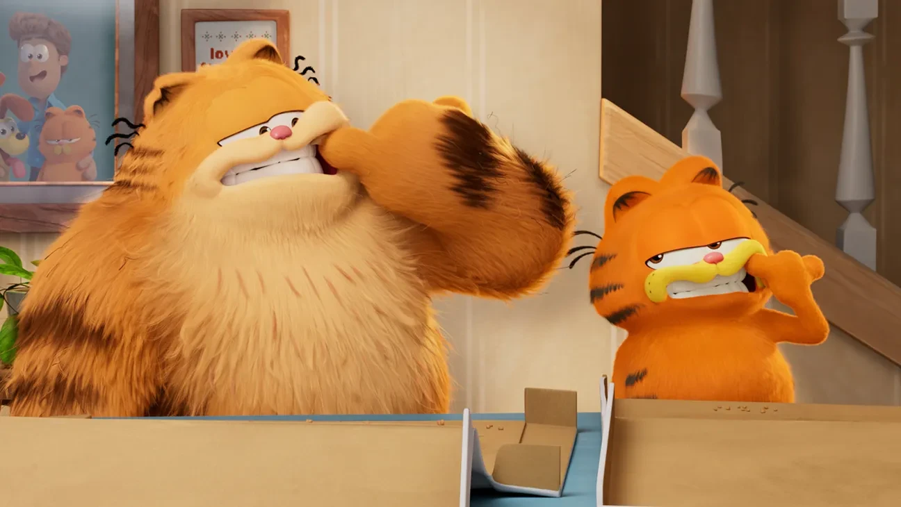 Garfield et son père Vic, côte à côte, se tirent la joue avec la patte