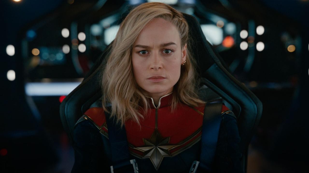 Brie Larson en Captain Marvel, assise dans le cockpit d’un vaisseau, le regard sérieux