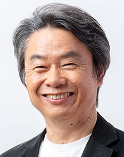 Portrait de Shigeru Miyamoto, souriant, en veste noire