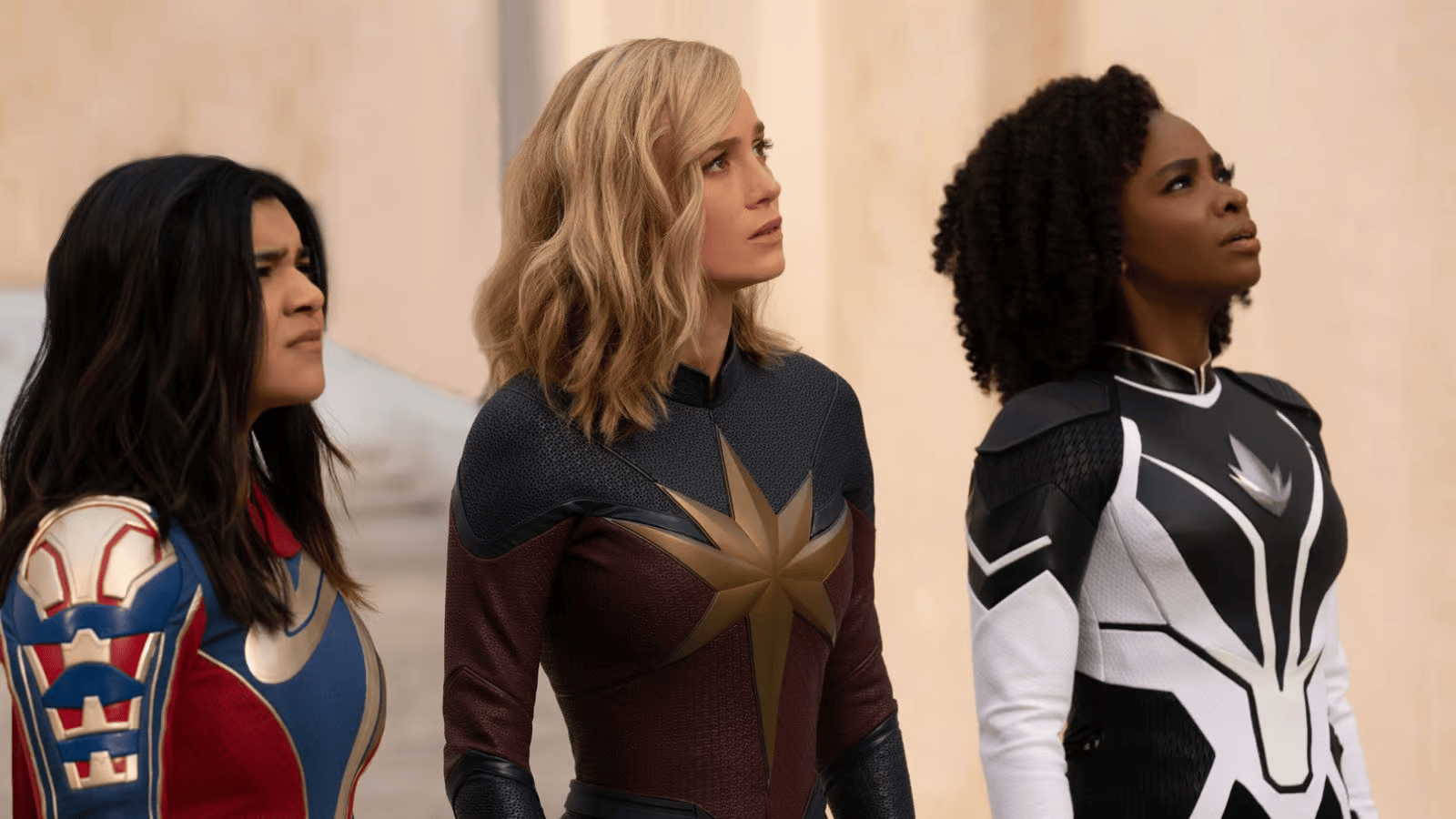 Miss Marvel, Captain Marvel et Photon côte à côte, en costume, levant les yeux vers le ciel