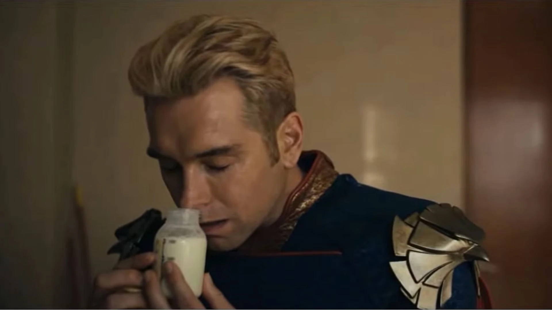 Homelander, yeux fermés, porte un biberon de lait à son visage dans la série The Boys