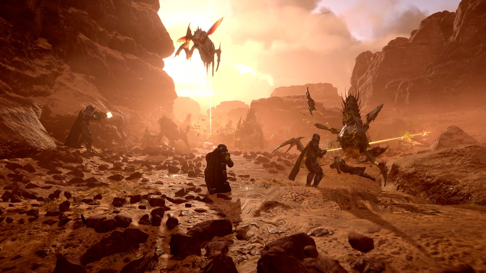 Escouade de Helldivers tirant sur des insectes géants dans un canyon rougeâtre
