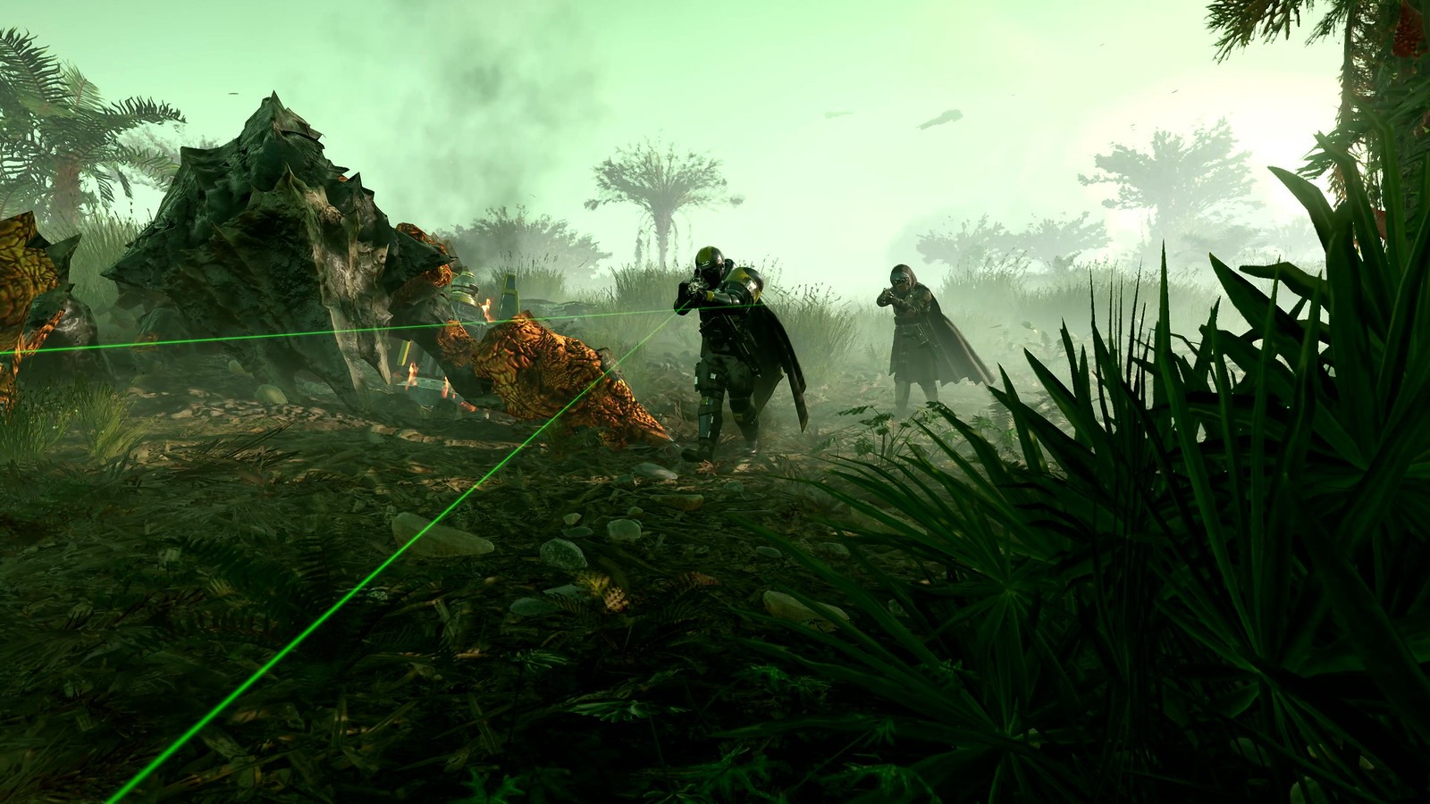 Deux Helldivers tirant au laser vert dans une végétation dense, près d’une carcasse d’insecte