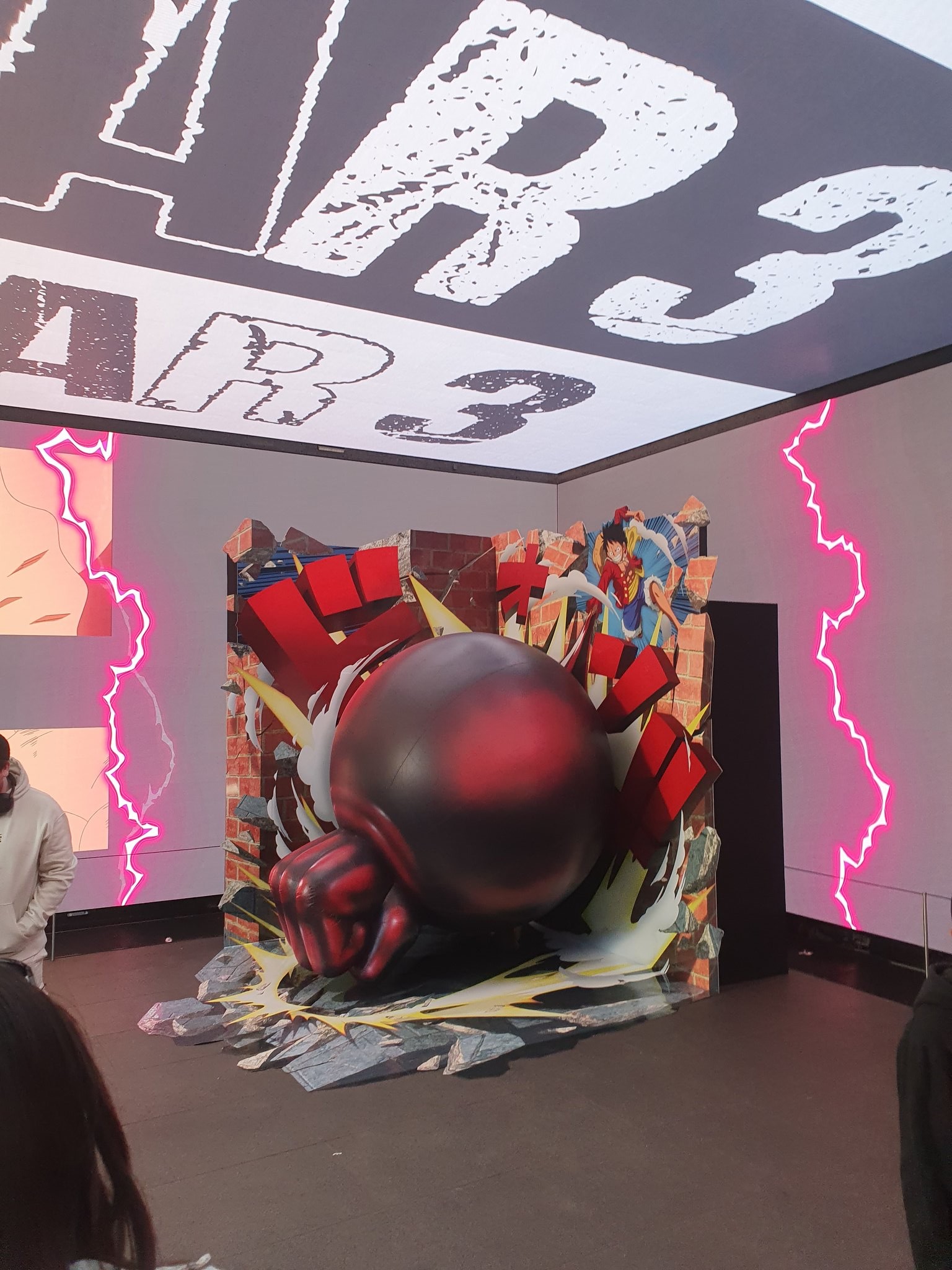 Installation du poing géant de Luffy en Gear 3 traversant un mur de briques