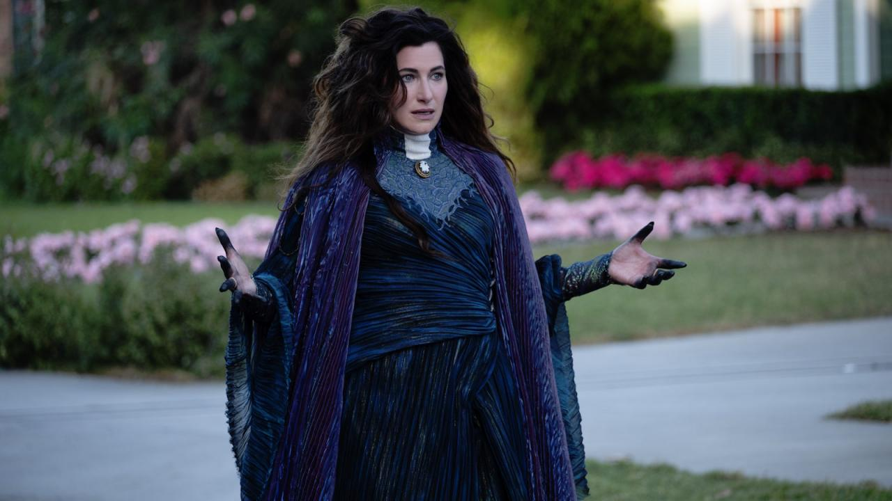 Agatha Harkness en robe et cape violettes dans une rue de Westview