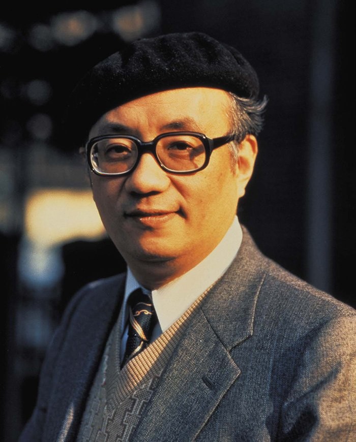 Portrait d’Osamu Tezuka, béret noir et lunettes, en costume gris