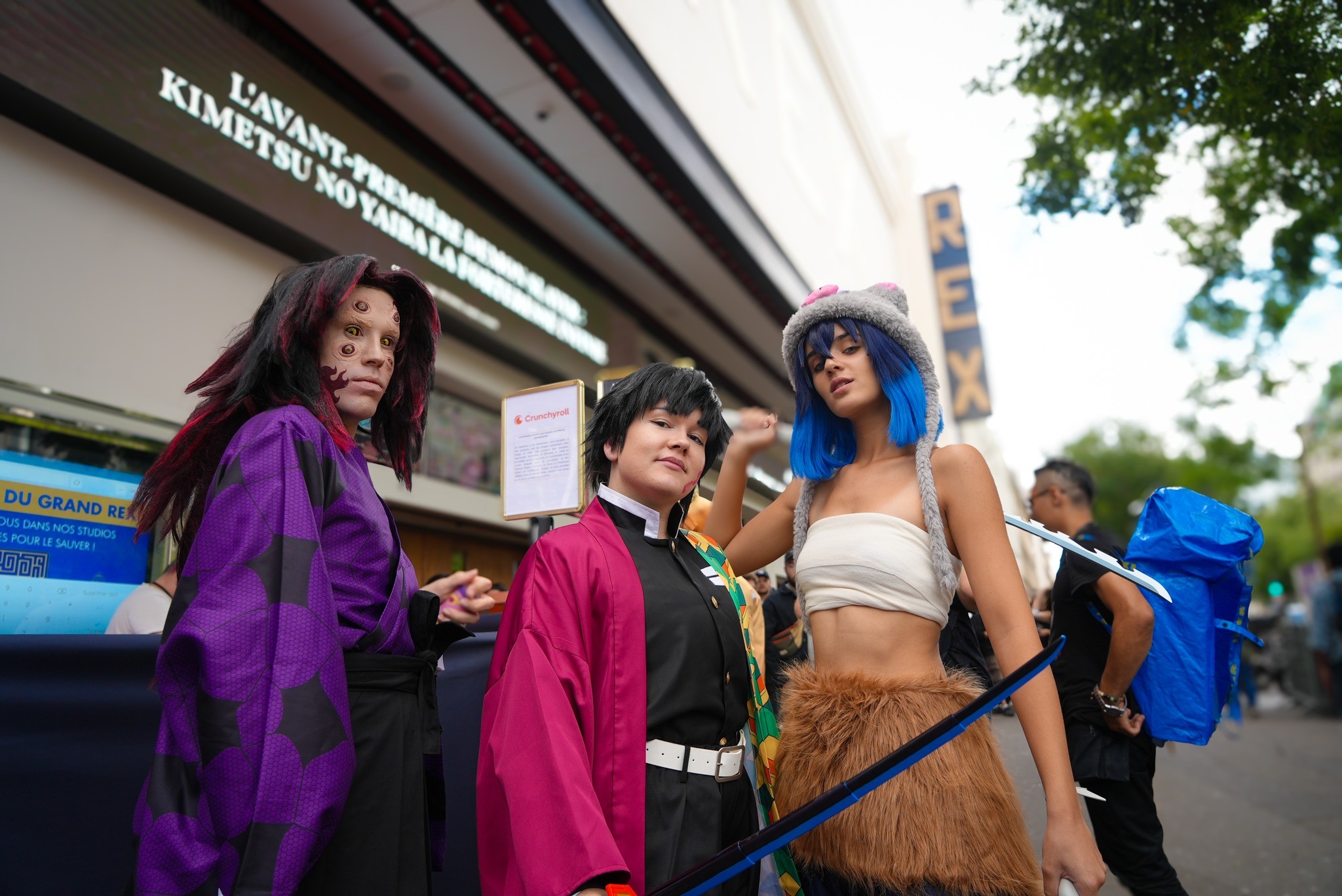 Cosplayeurs de Muzan, Giyu et Inosuke devant le Grand Rex, sous l’annonce de l’avant-première